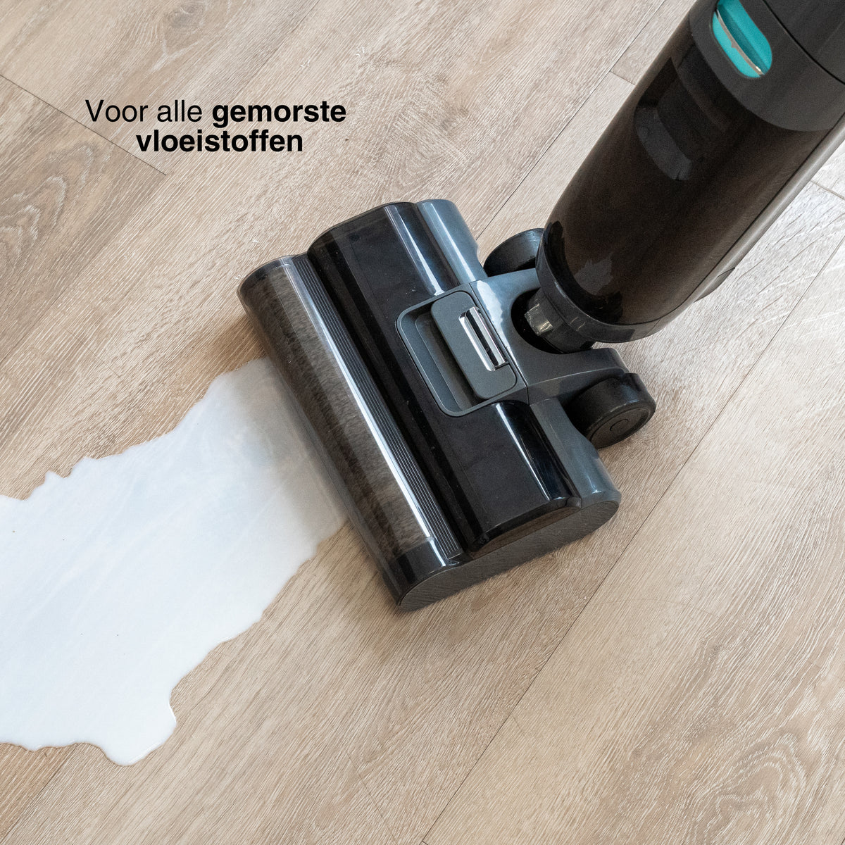 Close-up of a cordless stick vacuum cleaner head actively cleaning spilled liquid on a wooden floor.