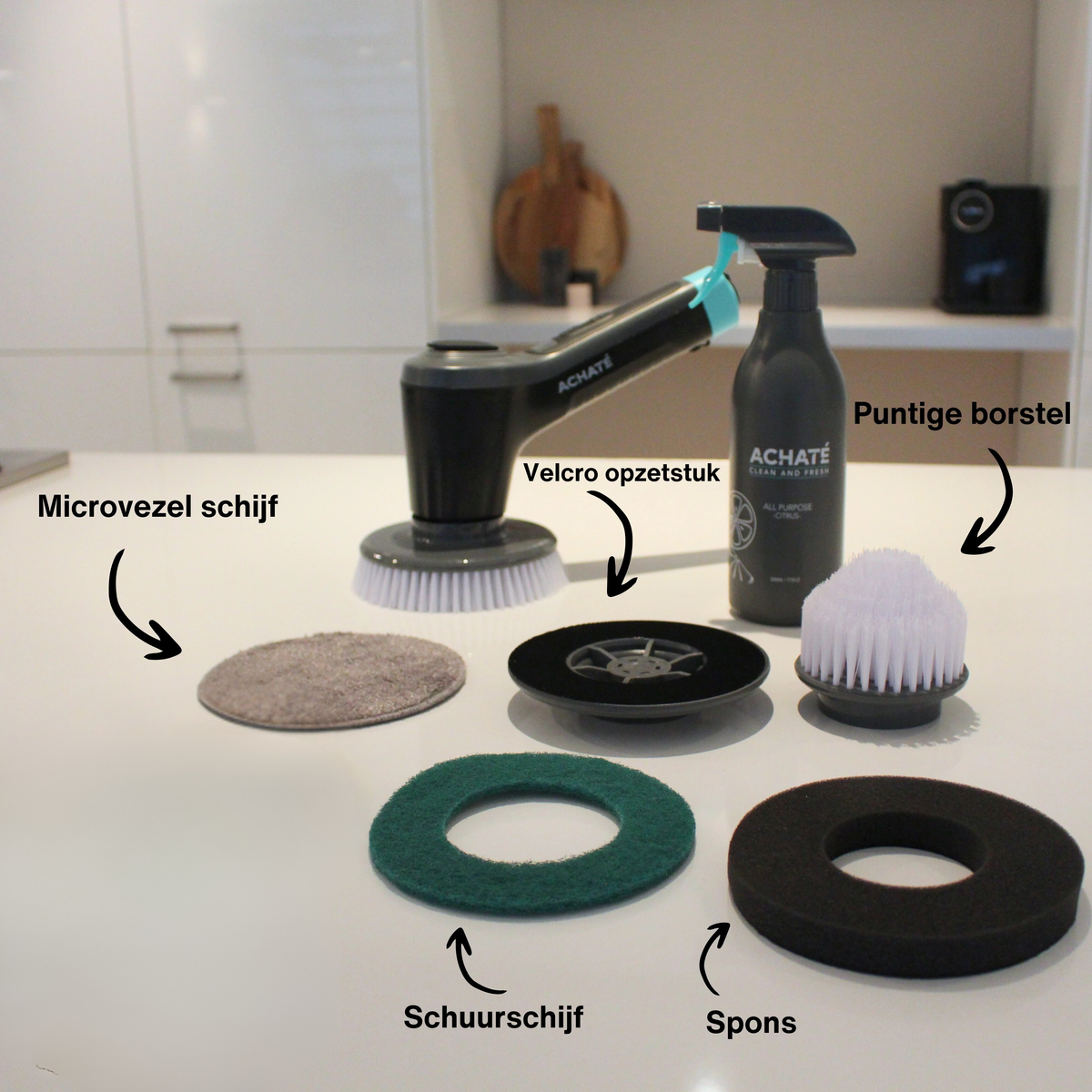 Achaté handheld steam cleaner with detachable cleaning brushes, scrub pad, sponge, microfiber cloth, and spray bottle on a kitchen countertop.
