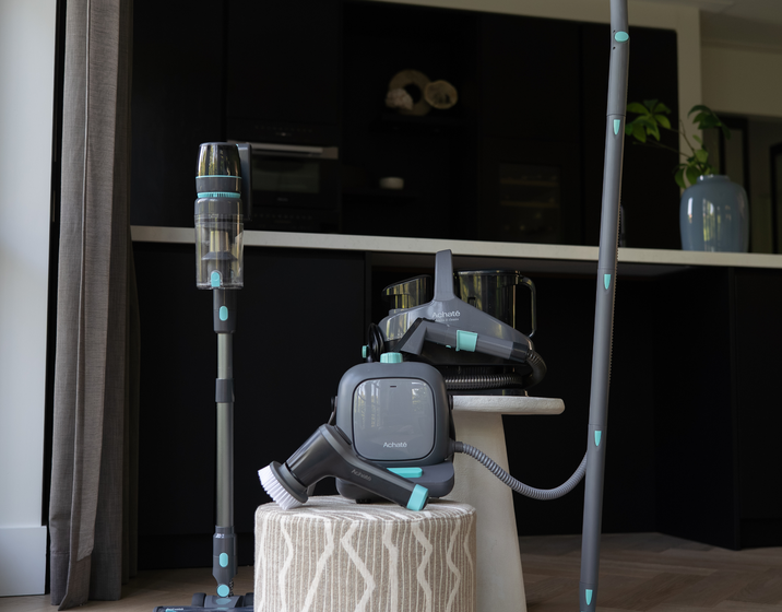 Achate schoonmaakbundel met steelstofzuiger, stoomreiniger, vlekkenreiniger en elektrische dweil in een woonkamer
