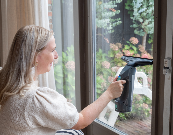 Achate Elektrische Raamwisser trekt water van een raam